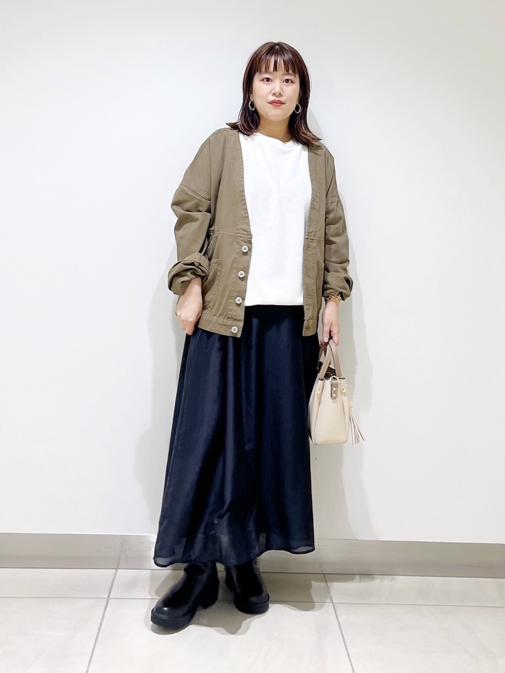 ホワイト系のTシャツ/カットソー、グリーン系のジャケット/アウター、ブラック系のスカートを着用したレディースの夏コーディネートの4枚目の写真