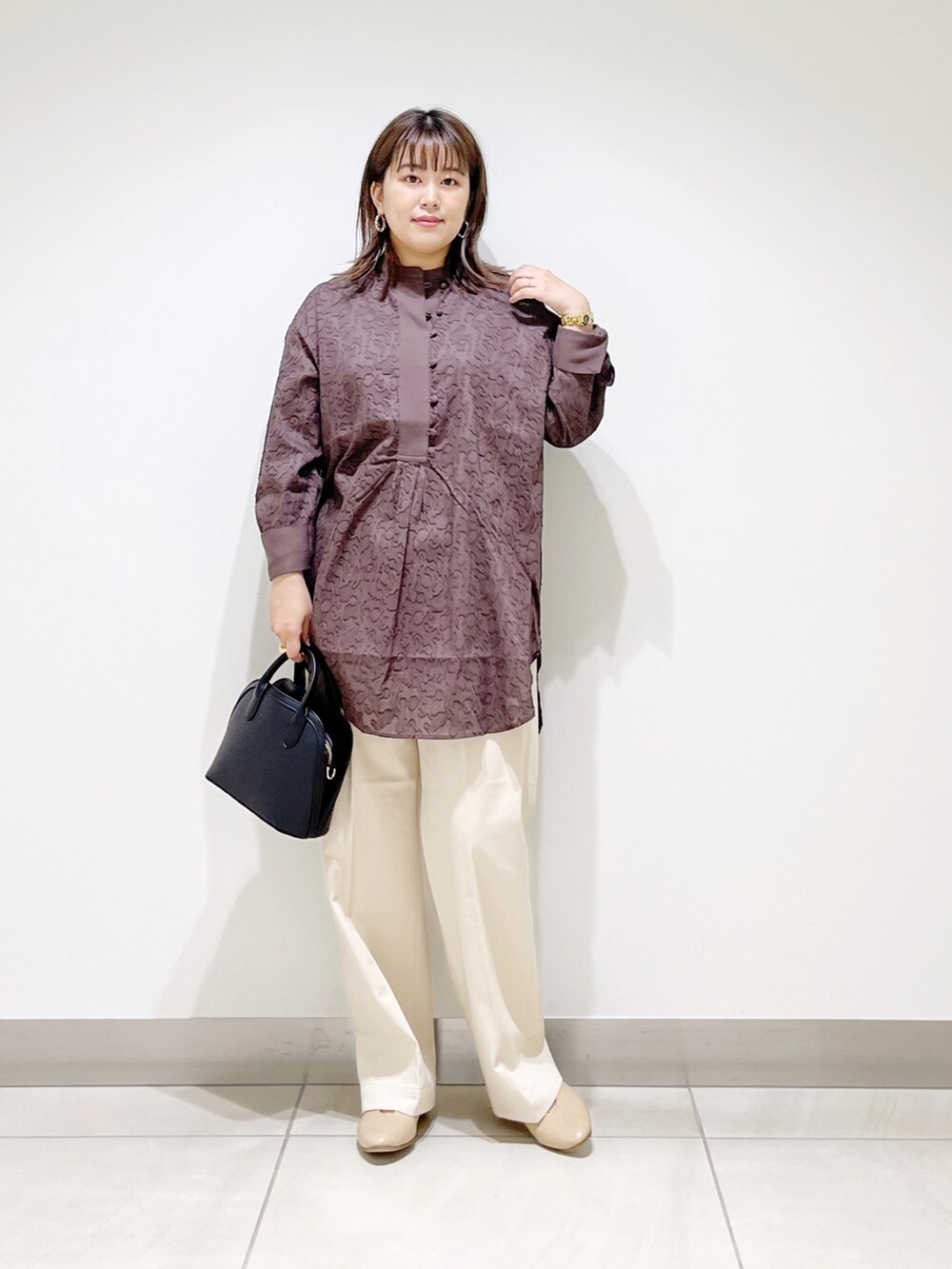 ブラウン系のシャツ/ブラウス、ブラック系のショルダーバッグ、ベージュ系のその他パンツを着用したレディースの秋コーディネートの4枚目の写真