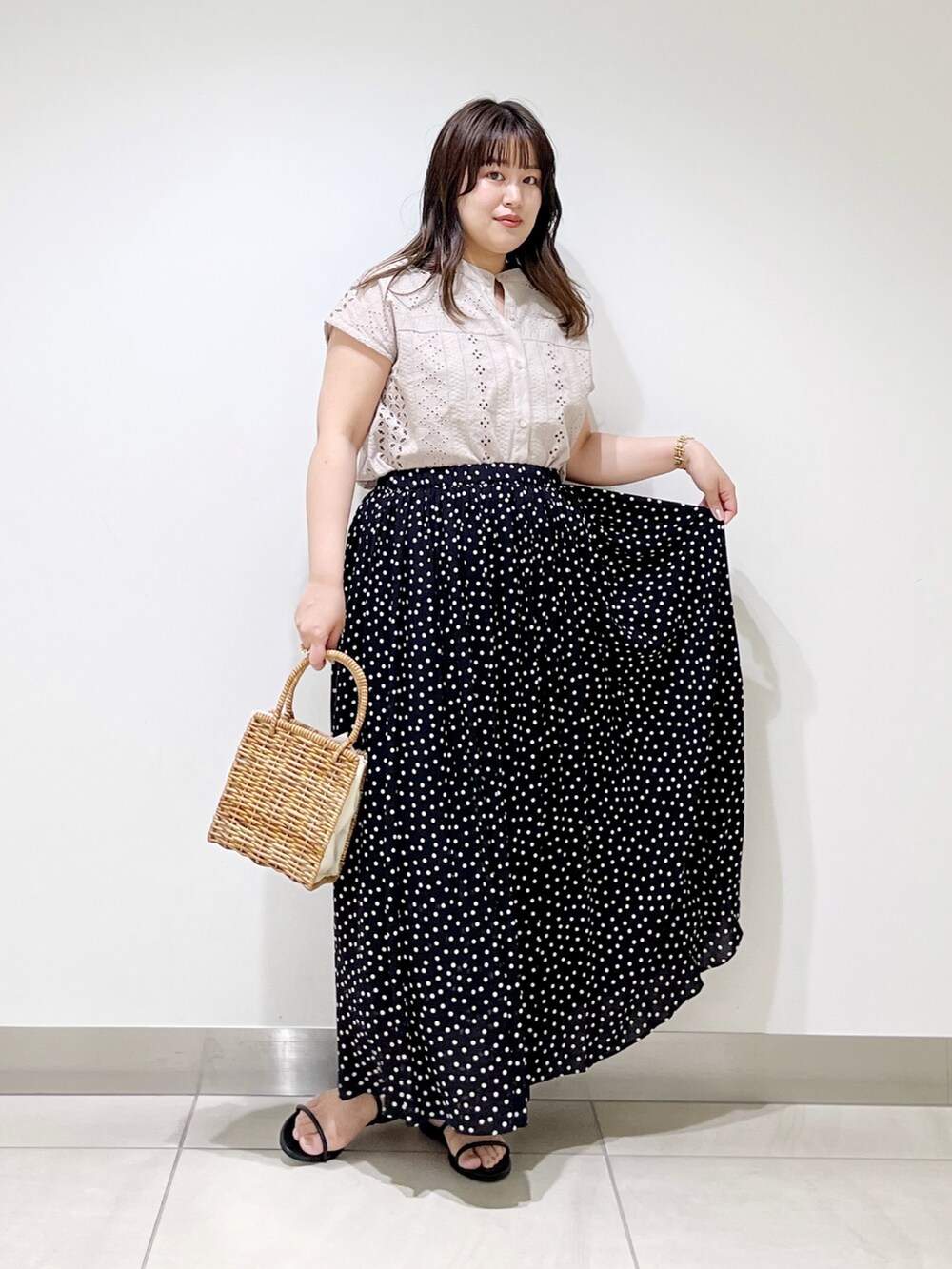 ブラック系のスカート、グレー系のシャツ/ブラウス、ベージュ系のハンドバッグを着用したレディースの春コーディネートの3枚目の写真