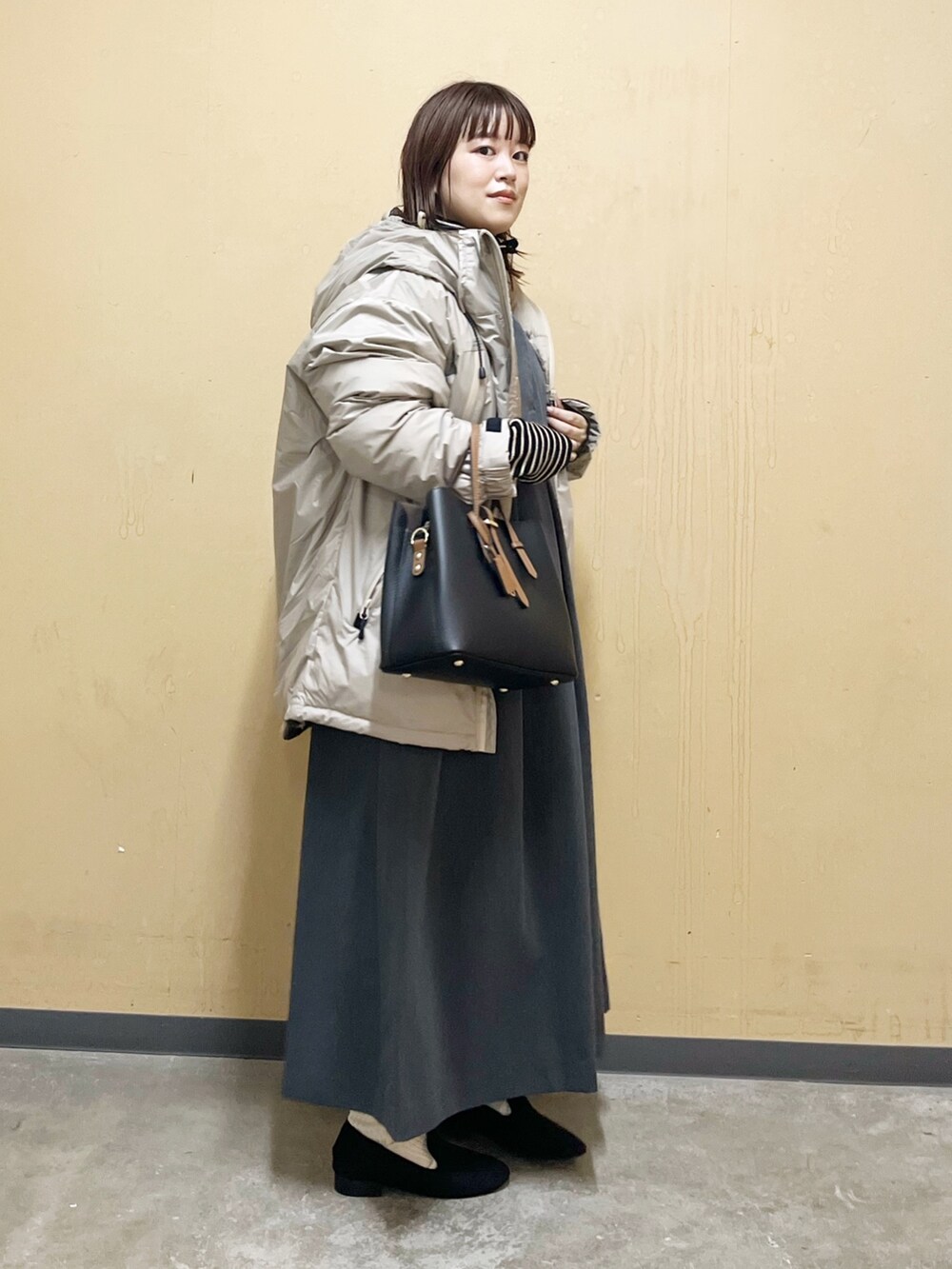 ベージュ系のダウンジャケット/コート、ブラック系のニット/セーター、グレー系のワンピース/ドレスを着用したレディースの秋コーディネートの7枚目の写真