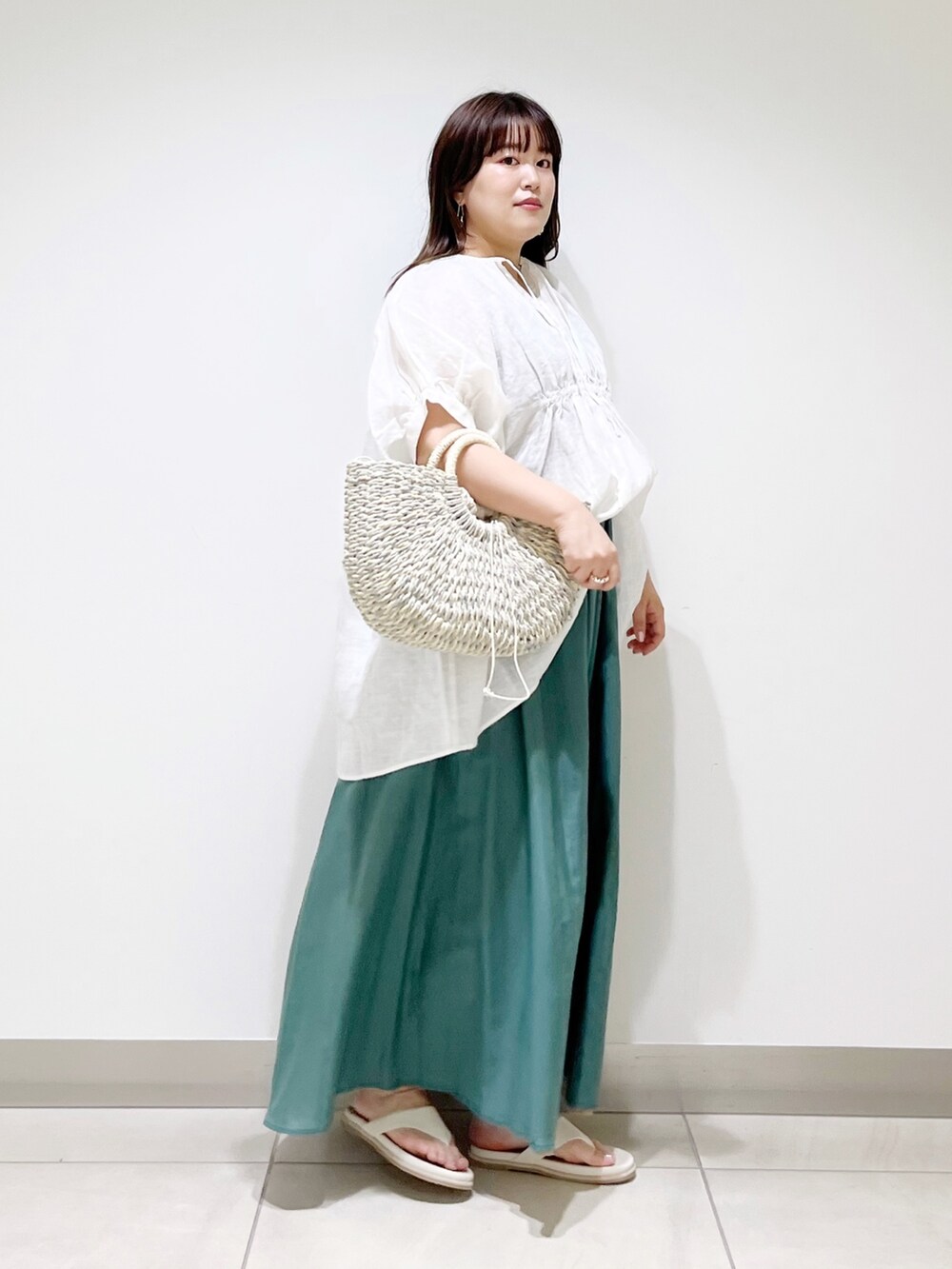 ホワイト系のシャツ/ブラウス、グリーン系のスカート、グレー系のかごバッグを着用したレディースの夏コーディネートの5枚目の写真