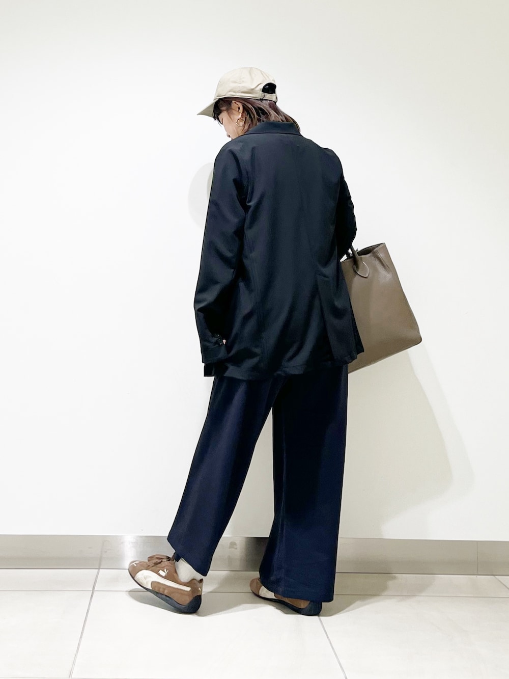 ブラック系のその他アウター、グレー系のニット/セーター、グレー系のトートバッグを着用したレディースの秋コーディネートの5枚目の写真