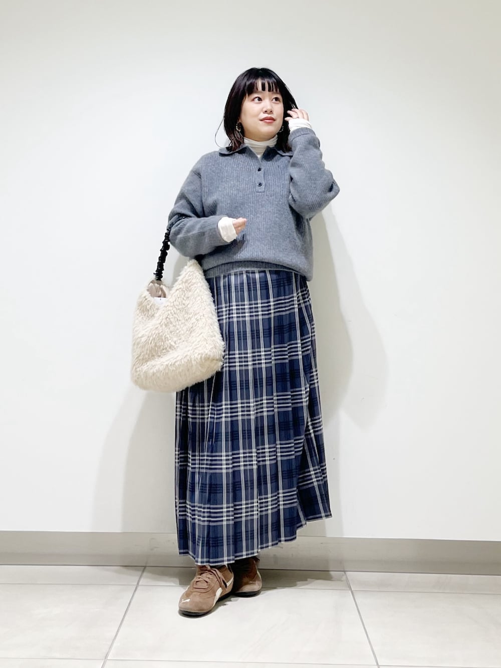 グレー系のニット/セーター、ホワイト系のTシャツ/カットソー、ホワイト系のバッグを着用したレディースの秋コーディネートの2枚目の写真
