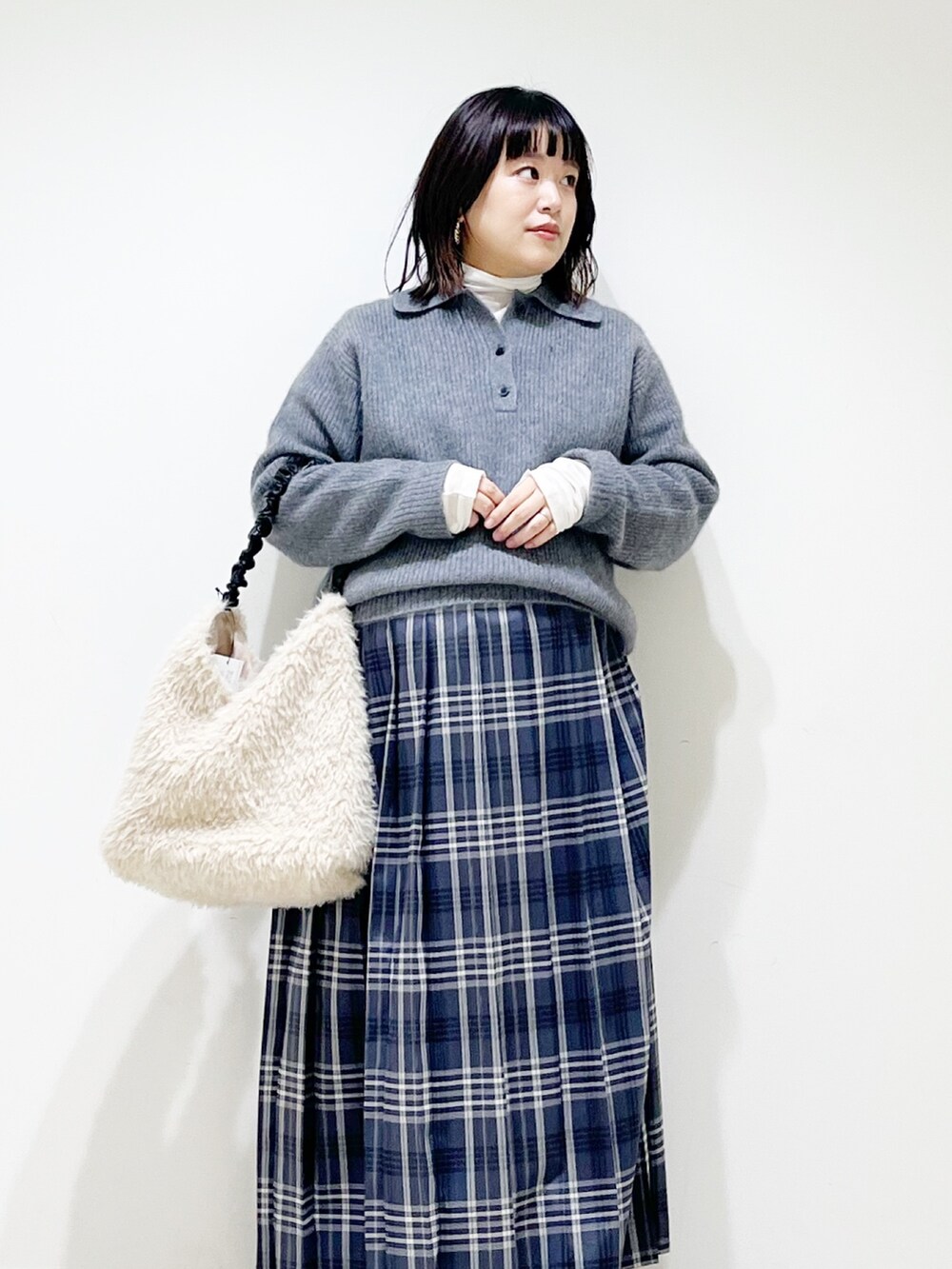 グレー系のニット/セーター、ホワイト系のTシャツ/カットソー、ホワイト系のバッグを着用したレディースの秋コーディネートの4枚目の写真