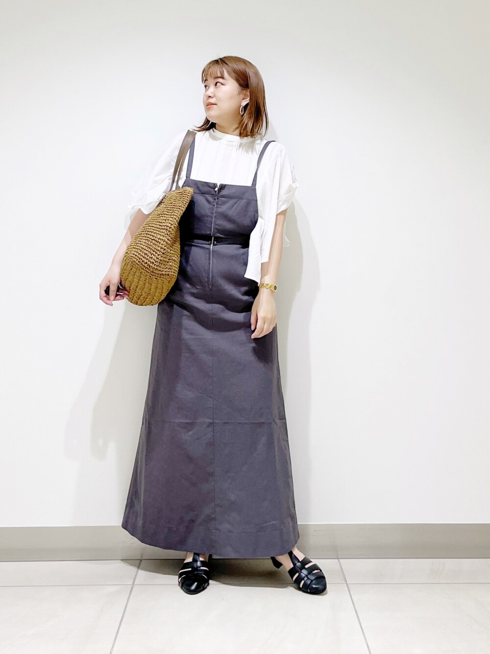 グレー系のワンピース、ホワイト系のシャツ/ブラウス、ベージュ系のトートバッグを着用したレディースの夏コーディネートの2枚目の写真