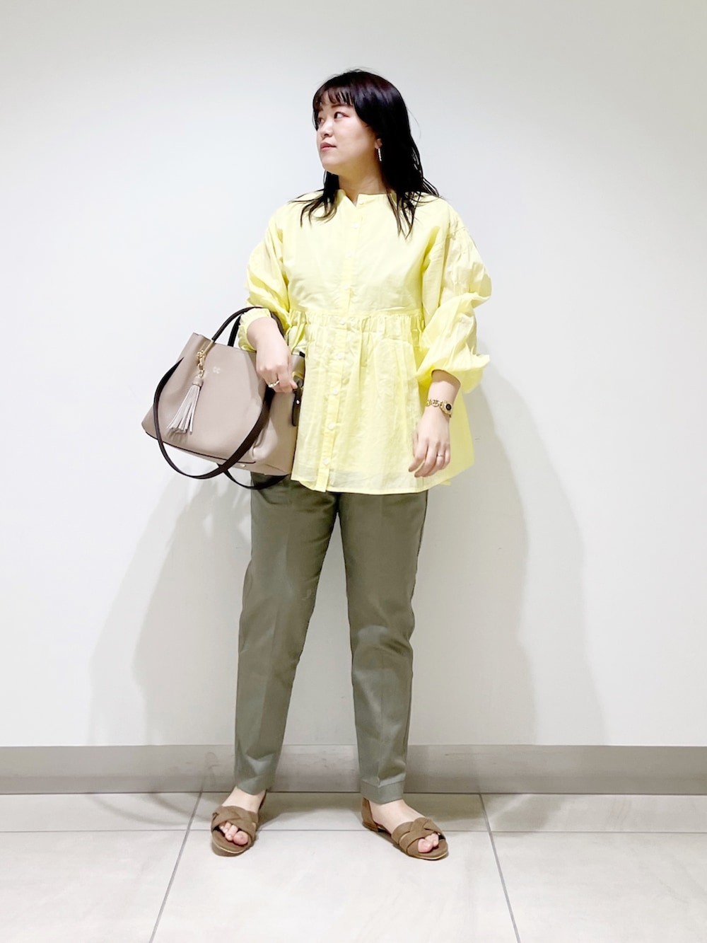 イエロー系のシャツ/ブラウス、グリーン系のその他パンツ、ベージュ系のトートバッグを着用したレディースの春コーディネートの4枚目の写真