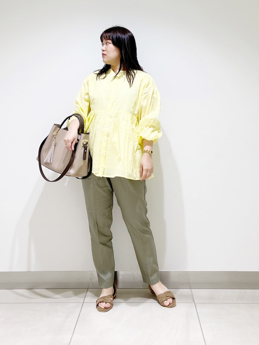イエロー系のシャツ/ブラウス、グリーン系のその他パンツ、ベージュ系のトートバッグを着用したレディースの春コーディネートの9枚目の写真