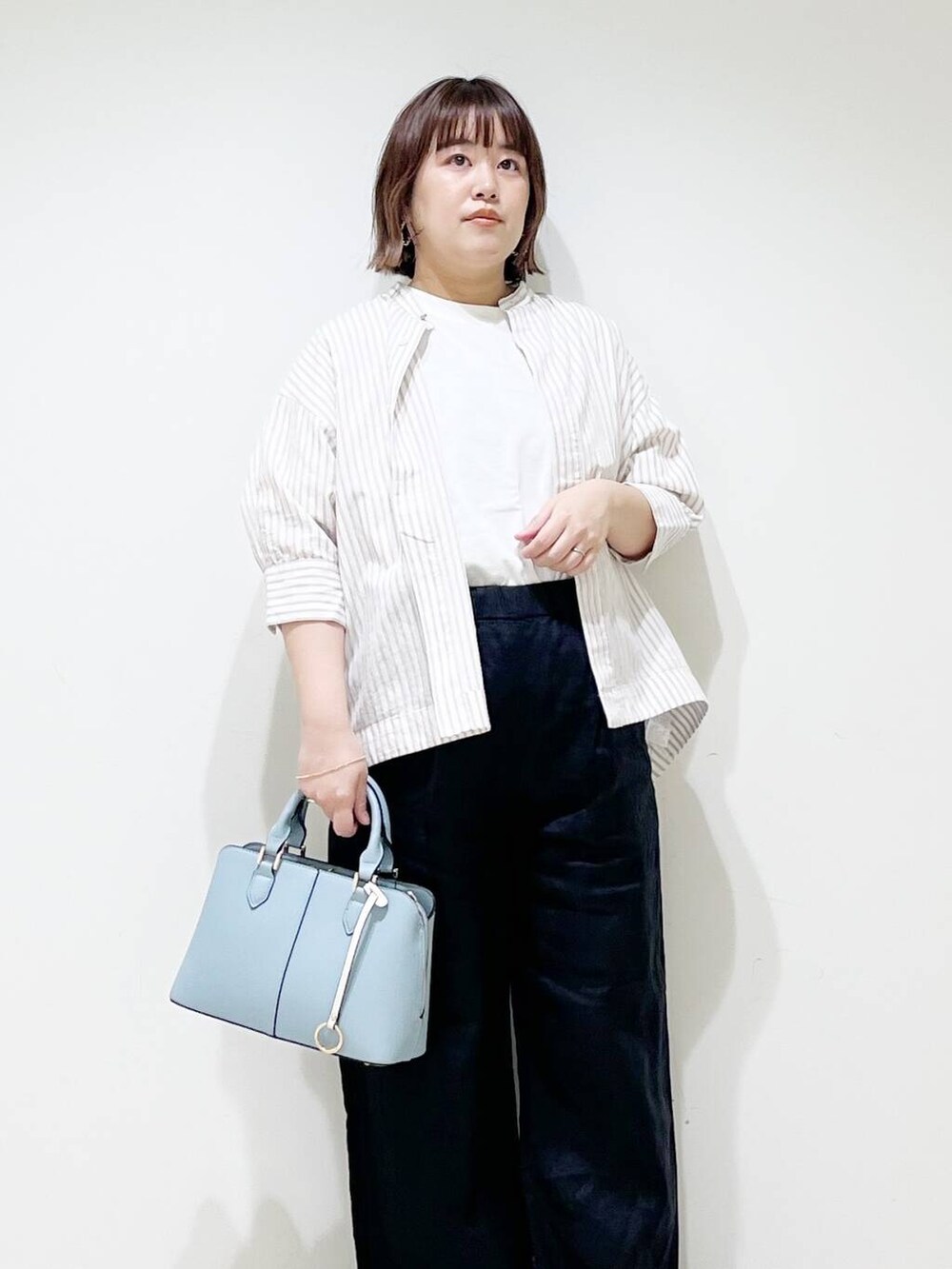 ブラック系のその他パンツ、ベージュ系のシャツ/ブラウス、イエロー系のサンダルを着用したレディースの春コーディネートの2枚目の写真