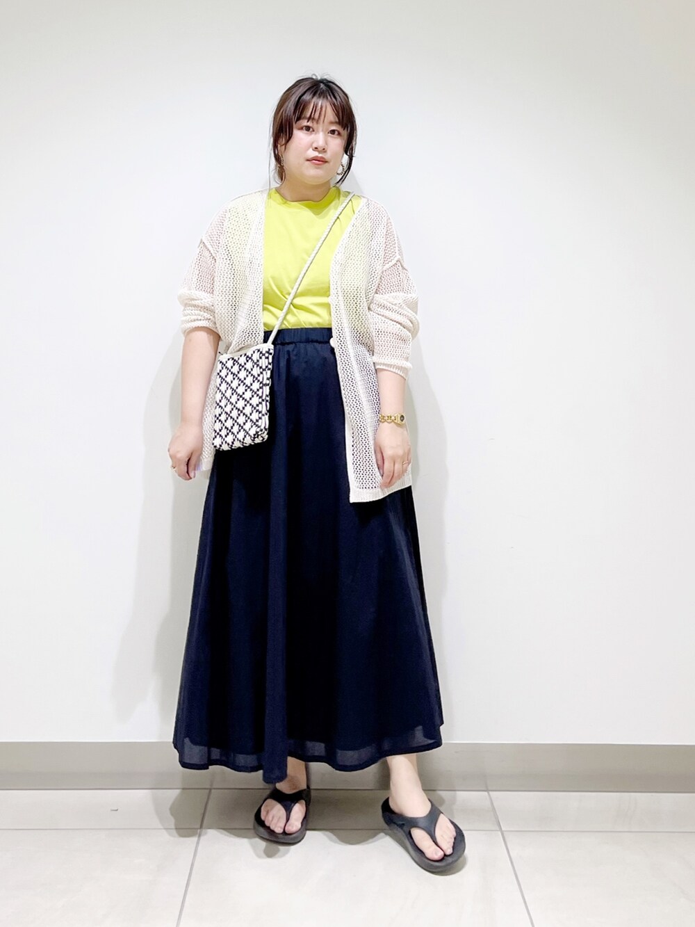 ホワイト系のカーディガン/ボレロ、ブラック系のショルダーバッグ、ブルー系のスカートを着用したレディースの春コーディネートの9枚目の写真