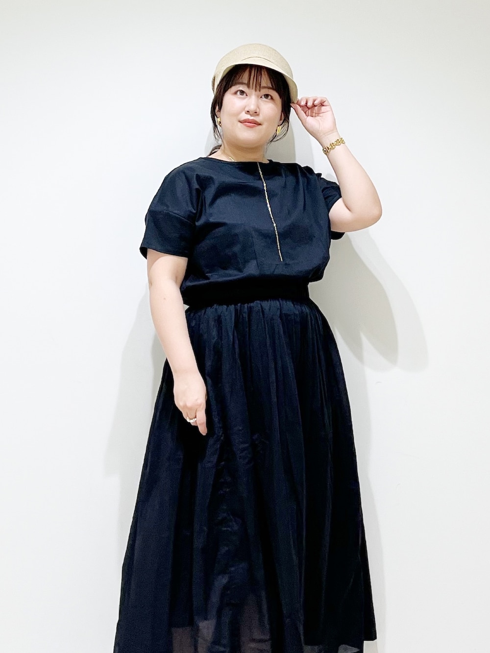 ブラック系のワンピース、ブラック系のサンダル、ベージュ系のキャスケットを着用したレディースの夏コーディネートの7枚目の写真