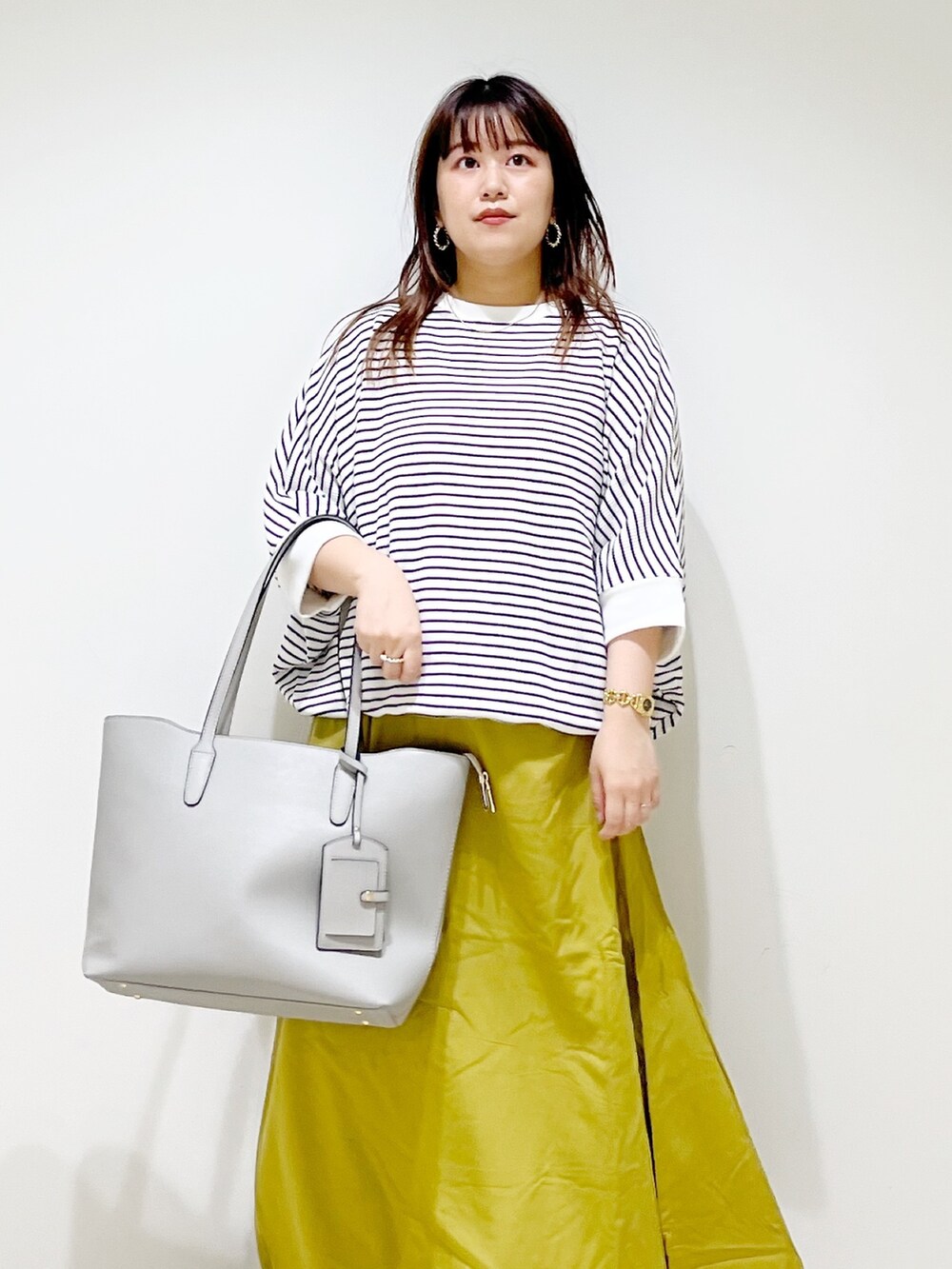 その他のスカート、グレー系のスニーカー、グレー系のトートバッグを着用したレディースの夏コーディネートの5枚目の写真