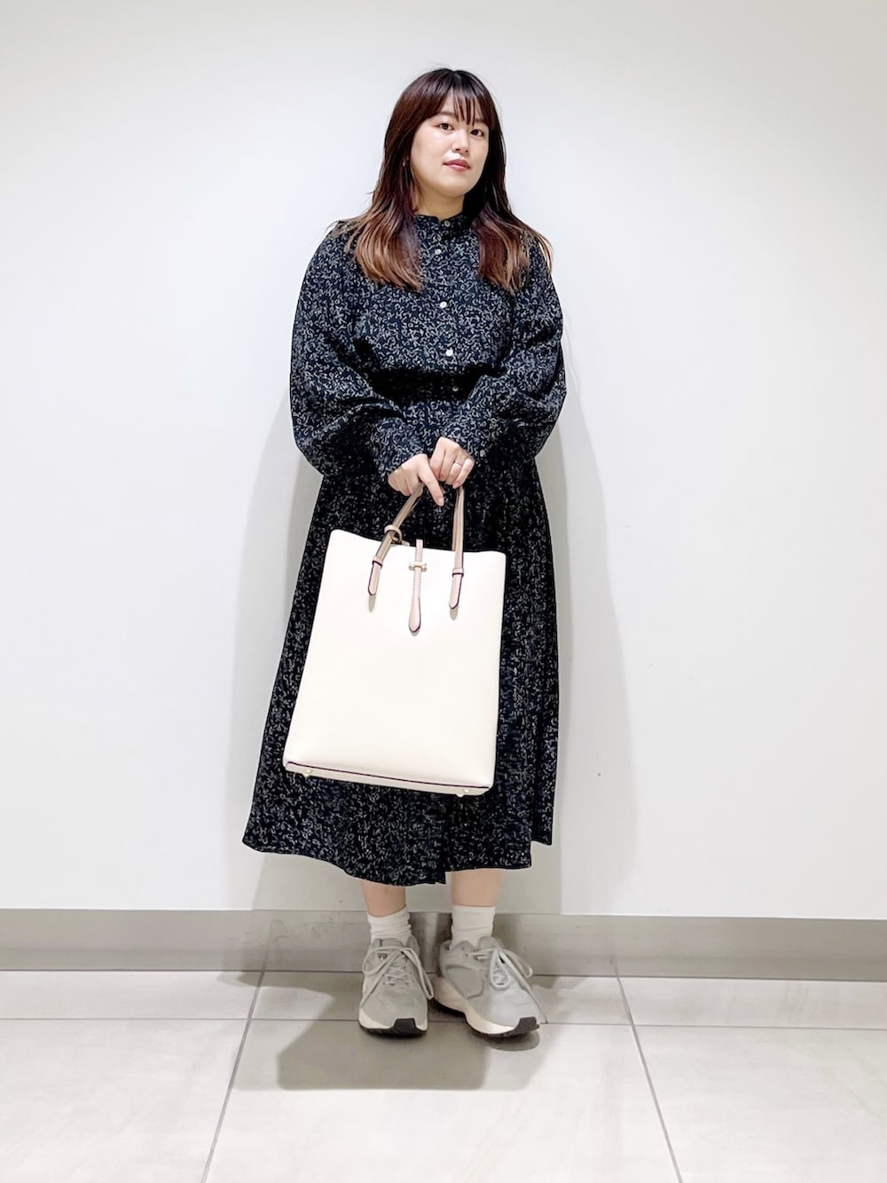 ブラック系のワンピース、ホワイト系のトートバッグ、グレー系のスニーカーを着用したレディースの夏コーディネートの3枚目の写真