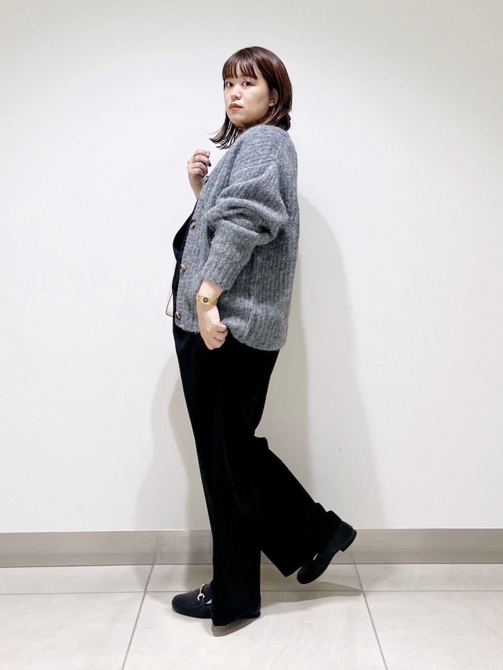 ブルー系のニット/セーター、グレー系のカーディガン/ボレロ、ブラック系のサロペット/オーバーオールを着用したレディースの秋コーディネートの9枚目の写真