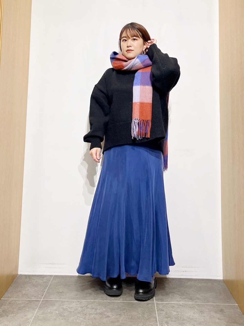 ブラック系のニット/セーター、ブルー系のスカート、ブラック系のブーツを着用したレディースの冬コーディネートの5枚目の写真