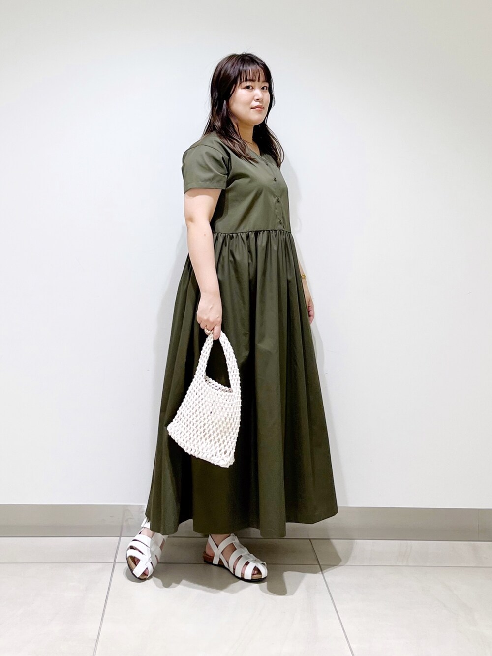 グリーン系のワンピース、ホワイト系のバッグ、ホワイト系のシューズを着用したレディースの春コーディネートの7枚目の写真