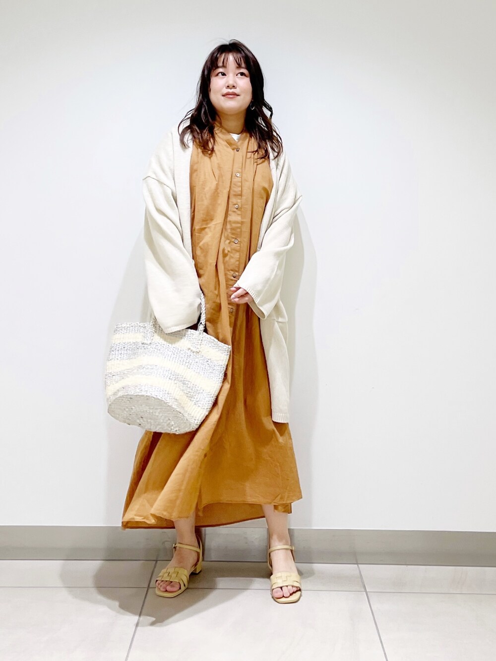 ブラウン系のワンピース、ホワイト系のカーディガン/ボレロ、ホワイト系のハンドバッグを着用したレディースの春コーディネートの5枚目の写真