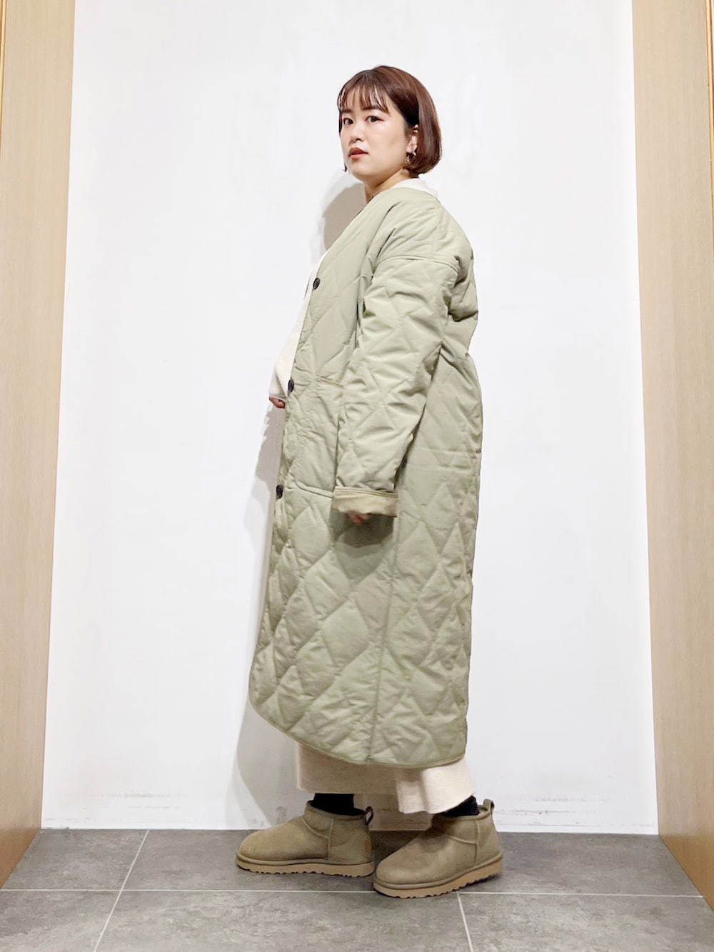 グリーン系のその他アウター、ベージュ系のスカート、グリーン系のブーツを着用したレディースの秋コーディネートの4枚目の写真