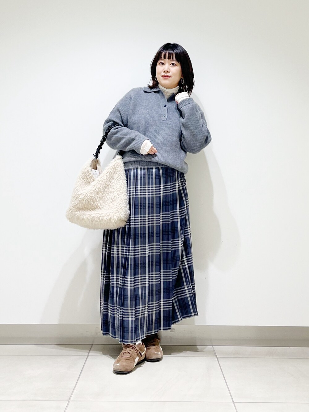 グレー系のニット/セーター、ホワイト系のTシャツ/カットソー、ホワイト系のバッグを着用したレディースの秋コーディネートの8枚目の写真