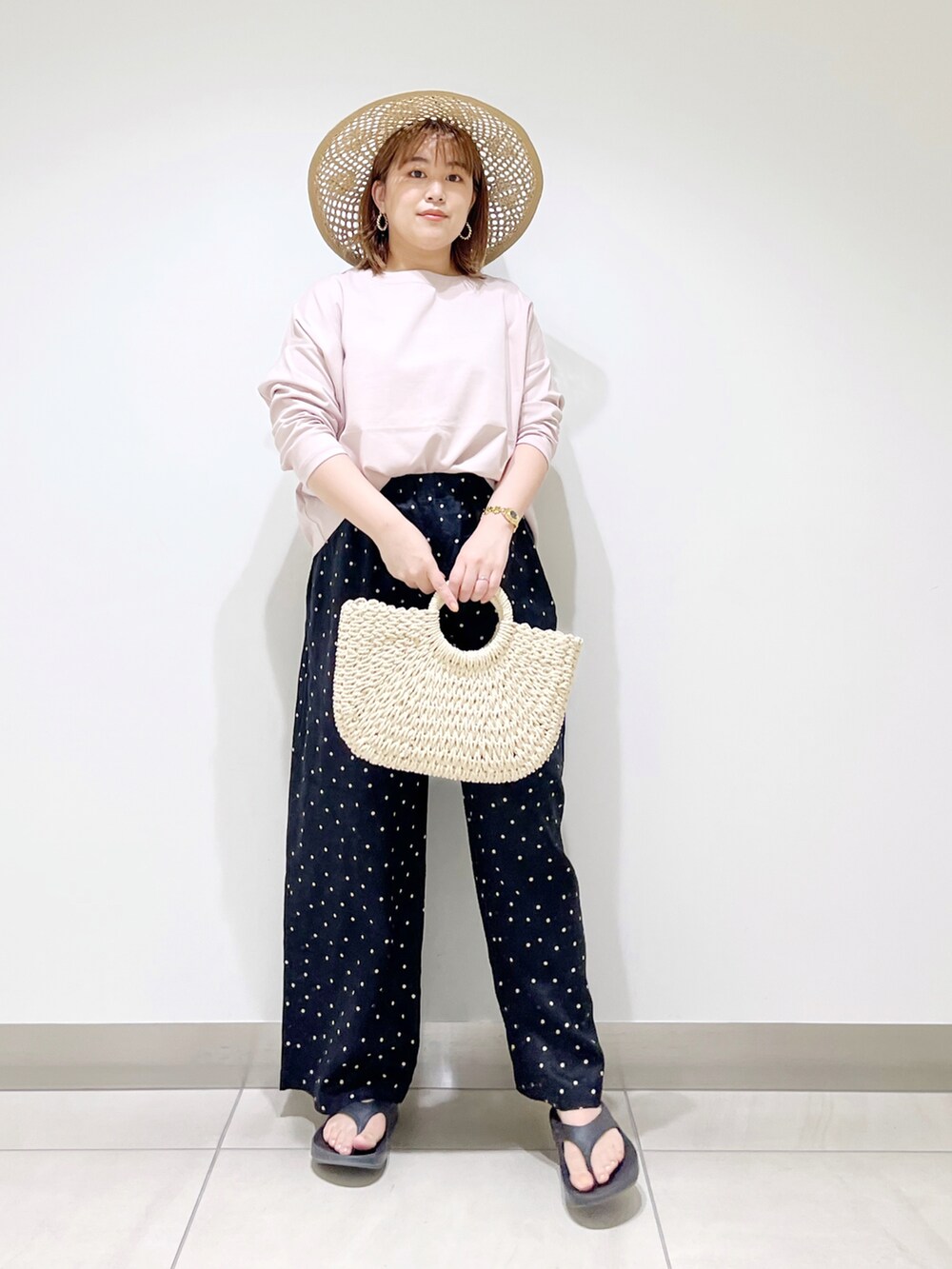 ブラック系のその他パンツ、ピンク系のTシャツ/カットソー、ホワイト系のハンドバッグを着用したレディースの春コーディネートの5枚目の写真