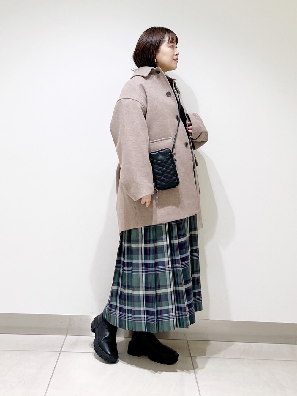 ブラウン系のその他アウター、ブラック系のニット/セーター、グリーン系のスカートを着用したレディースの秋コーディネートの9枚目の写真