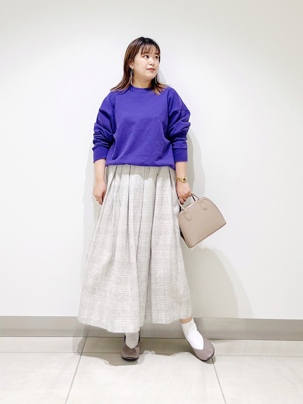 パープル系のスウェット、ホワイト系のスカート、ベージュ系のショルダーバッグを着用したレディースの秋コーディネートの5枚目の写真