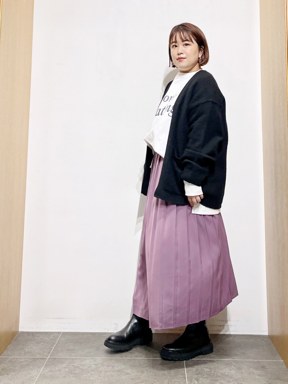 ホワイト系のTシャツ/カットソー、ブラック系のカーディガン/ボレロ、パープル系のスカートを着用したレディースの秋コーディネートの5枚目の写真
