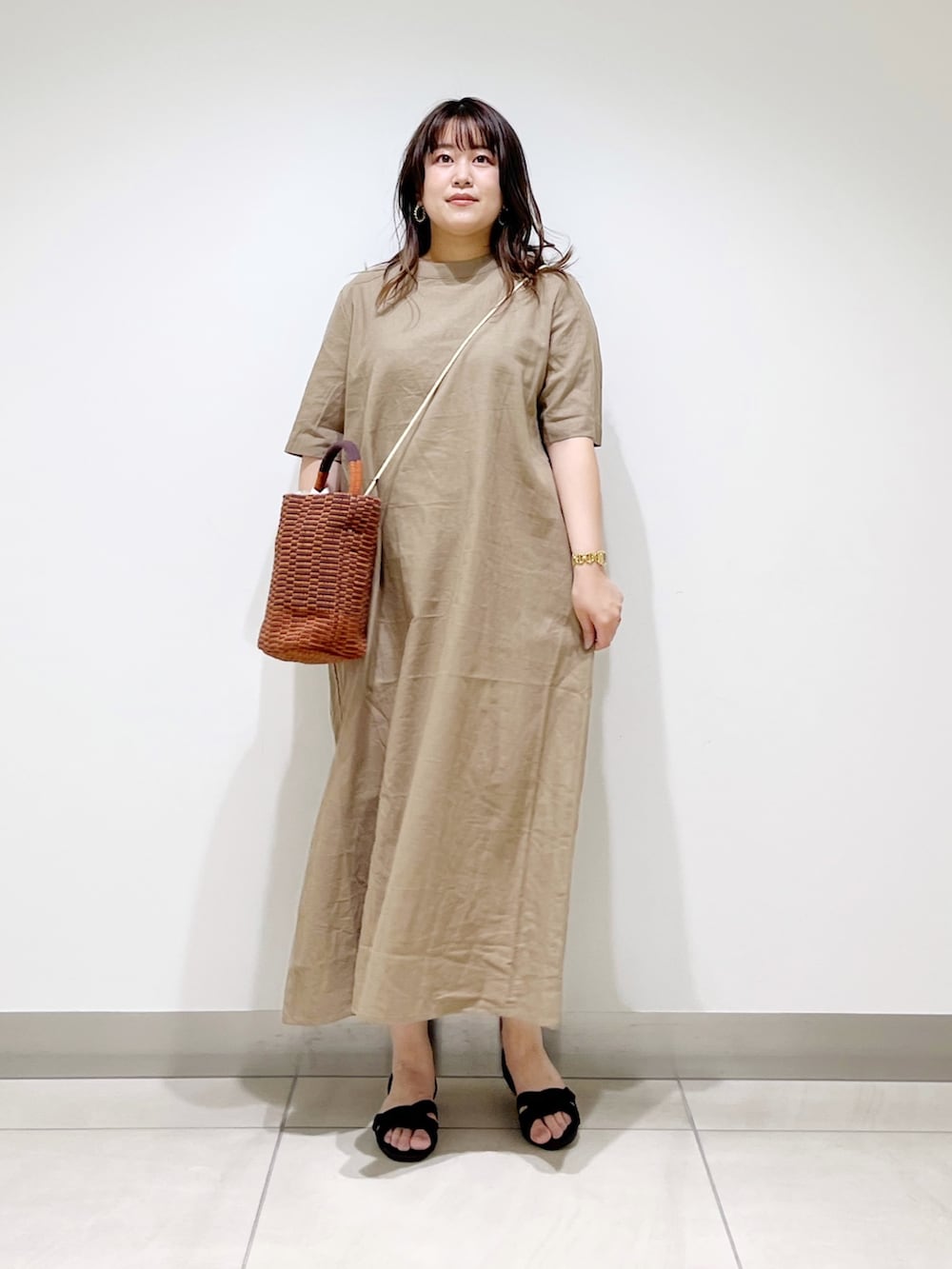 ベージュ系のワンピース、ブラウン系のショルダーバッグ、ブラック系のサンダルを着用したレディースの春コーディネートの7枚目の写真