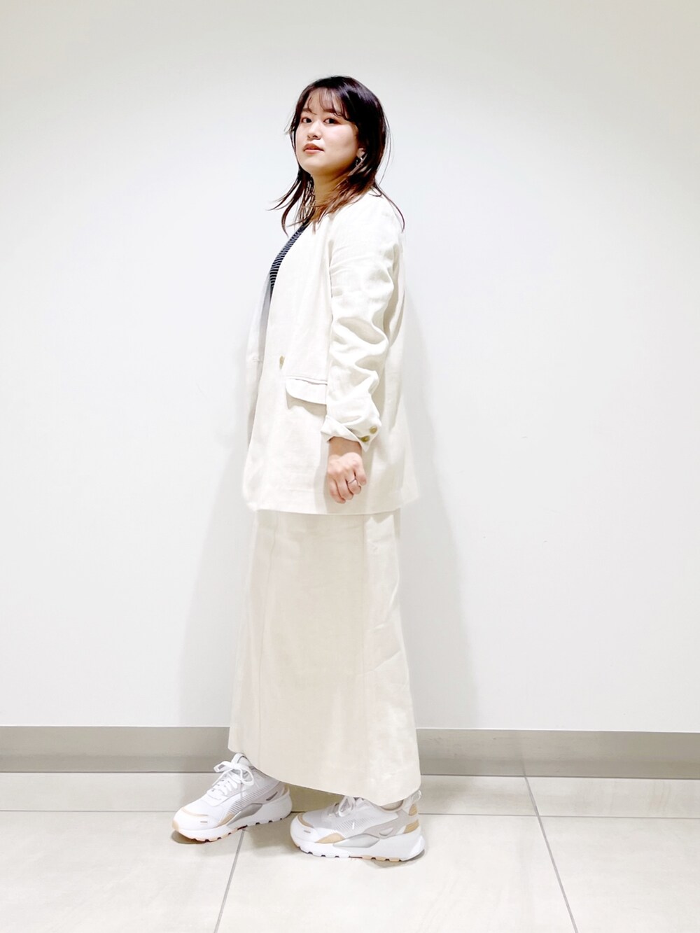 ベージュ系のスカート、ベージュ系のノーカラージャケット、ホワイト系のTシャツ/カットソーを着用したレディースの春コーディネートの4枚目の写真