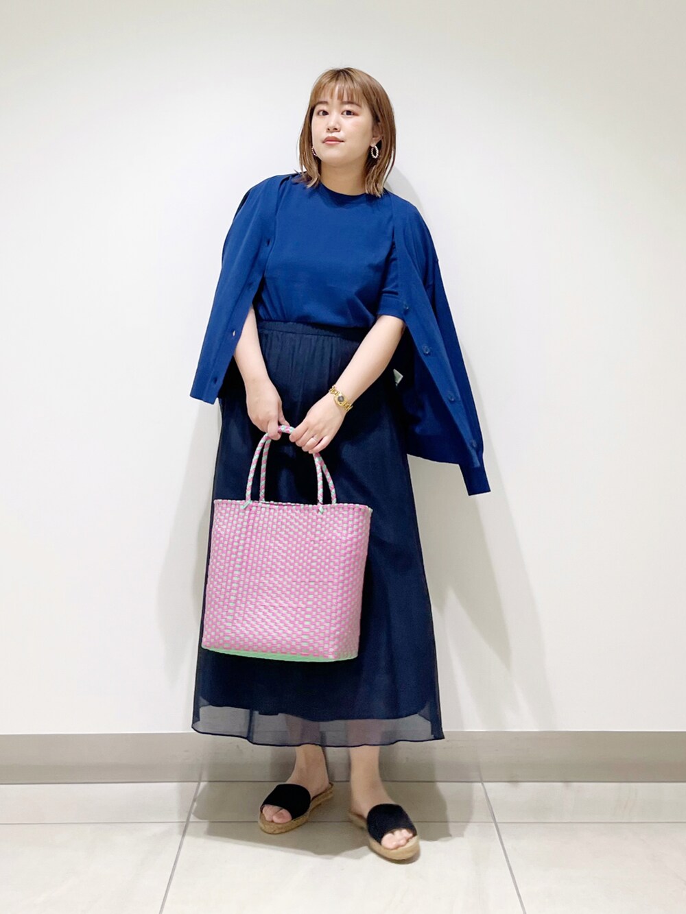 ブルー系のニット/セーター、ブルー系のカーディガン/ボレロ、ブルー系のスカートを着用したレディースの春コーディネートの2枚目の写真