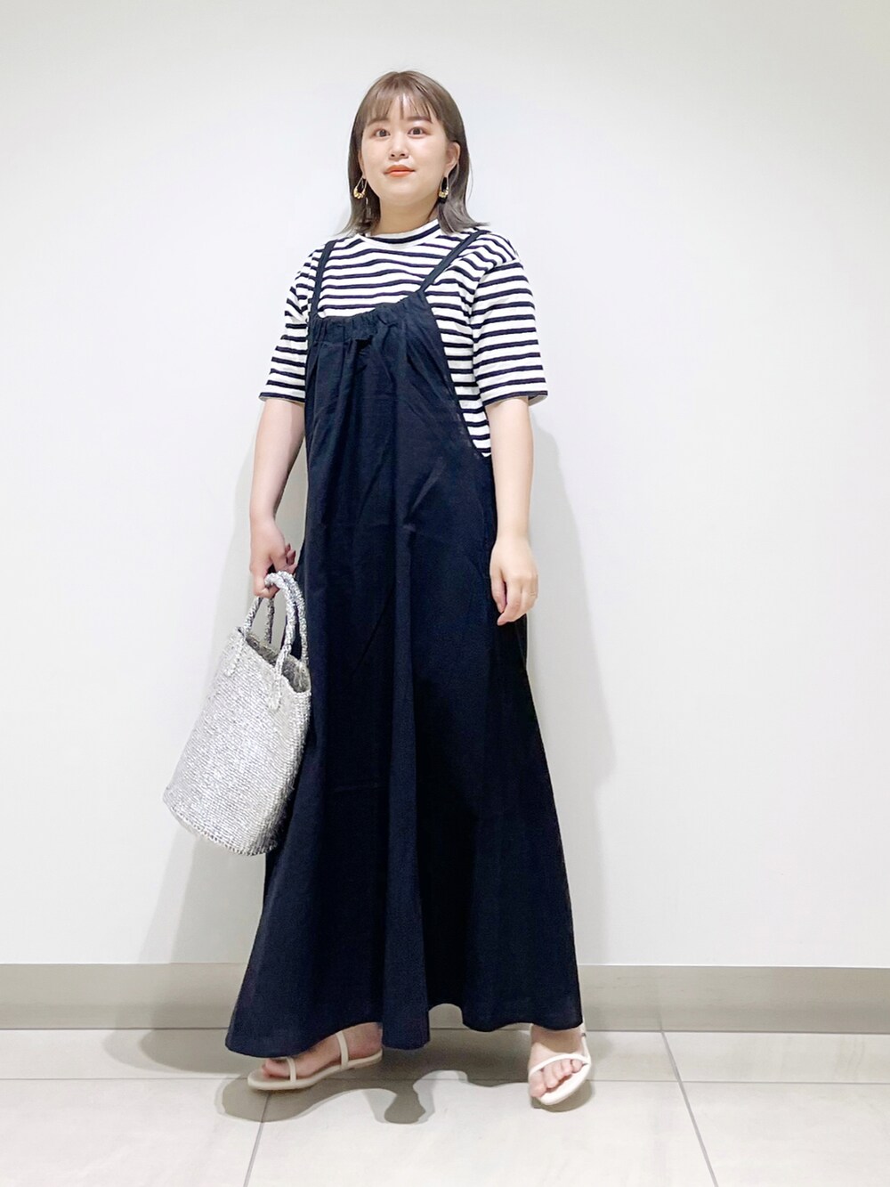 ブラック系のTシャツ/カットソー、ブラック系のワンピース、シルバー系のトートバッグを着用したレディースの春コーディネートの3枚目の写真