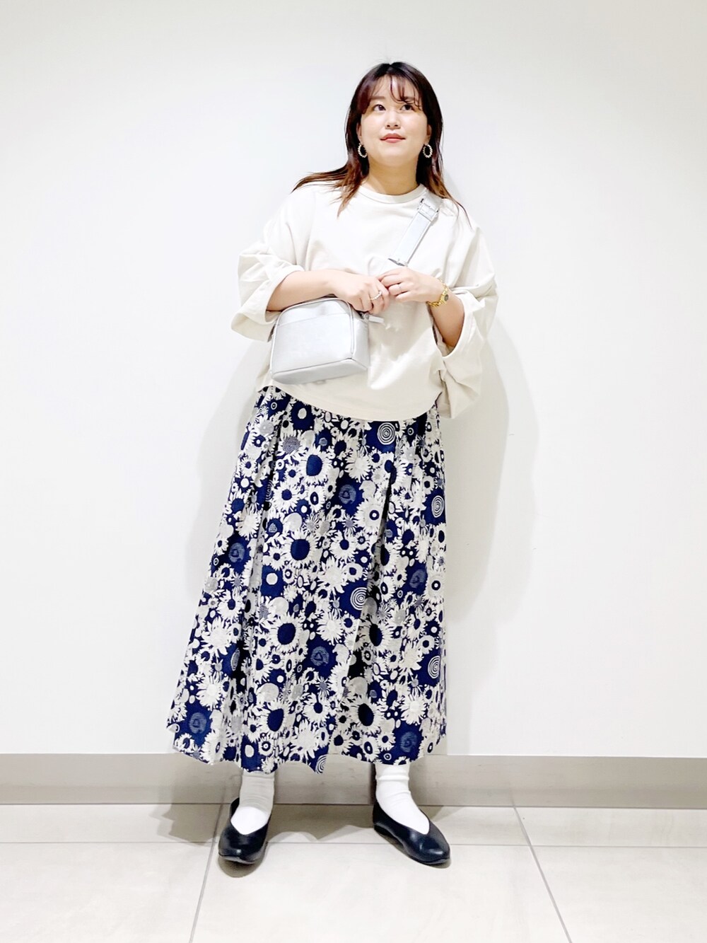 ベージュ系のTシャツ/カットソー、ブルー系のスカート、ブラック系のパンプスを着用したレディースの春コーディネートの2枚目の写真