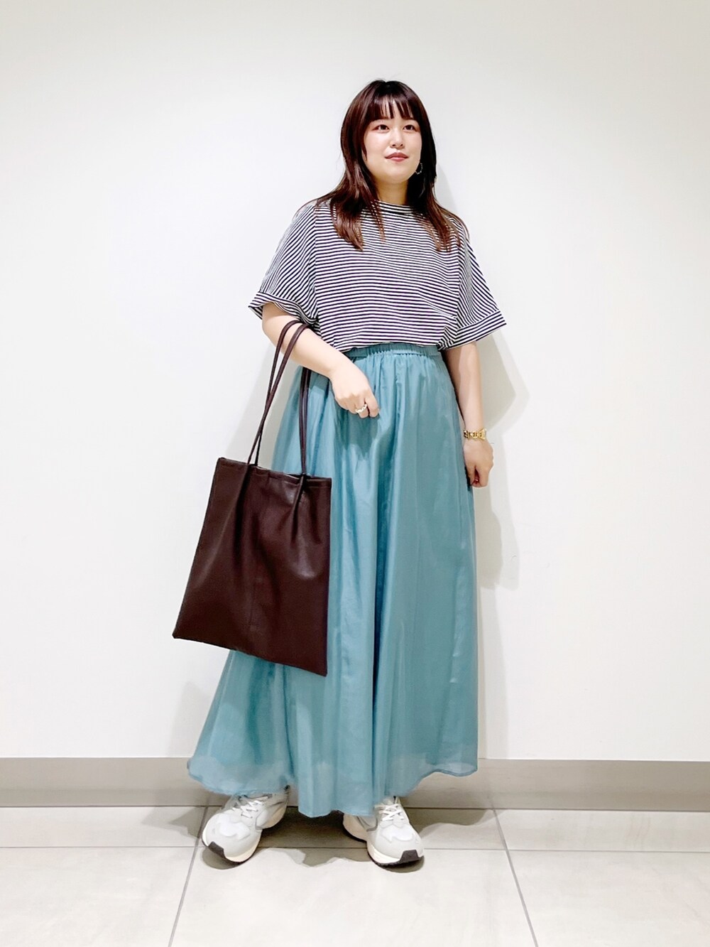 ホワイト系のTシャツ/カットソー、ホワイト系のスカート、ブラウン系のトートバッグを着用したレディースの夏コーディネートの5枚目の写真