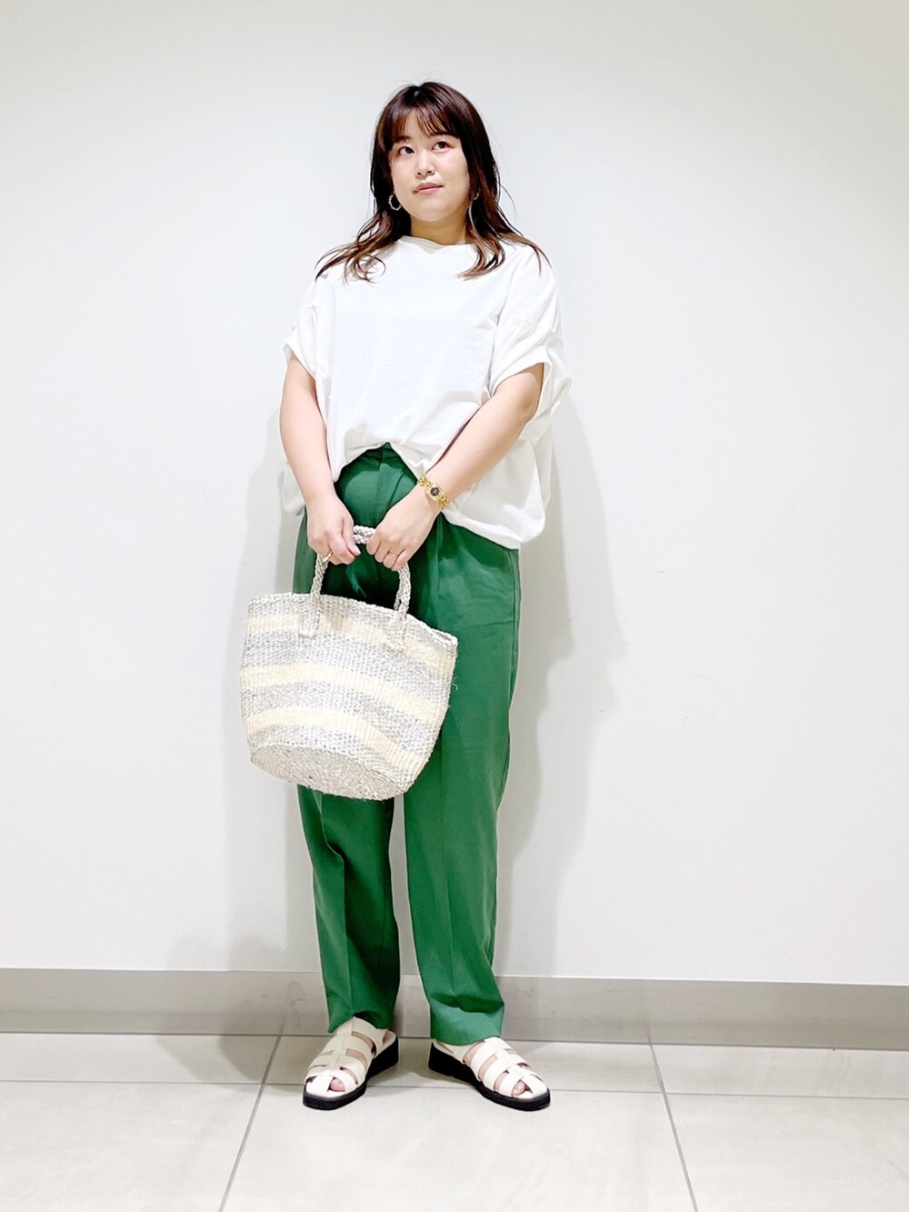 グリーン系のその他パンツ、ホワイト系のTシャツ/カットソー、ホワイト系のハンドバッグを着用したレディースの春コーディネートの2枚目の写真