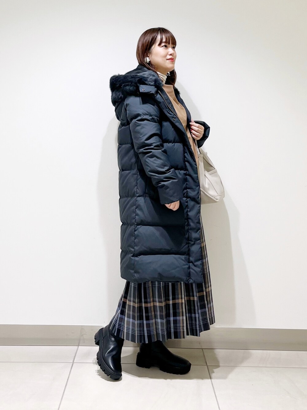 イエロー系のTシャツ/カットソー、ブラック系のダウンジャケット/コート、ブルー系のスカートを着用したレディースの秋コーディネートの9枚目の写真