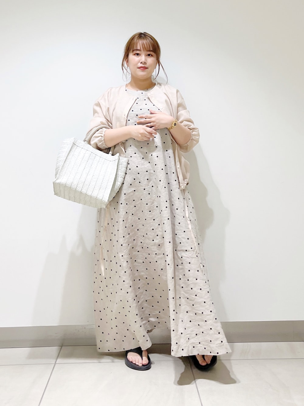 ベージュ系のカーディガン/ボレロ、ベージュ系のワンピース、ホワイト系のトートバッグを着用したレディースの春コーディネートの5枚目の写真