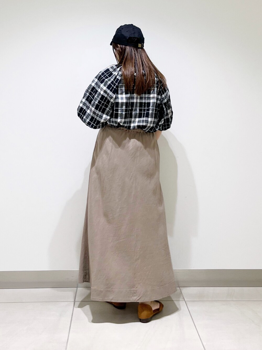 ベージュ系のスカート、ベージュ系のサンダル、ブラック系のシャツ/ブラウスを着用したレディースの夏コーディネートの3枚目の写真