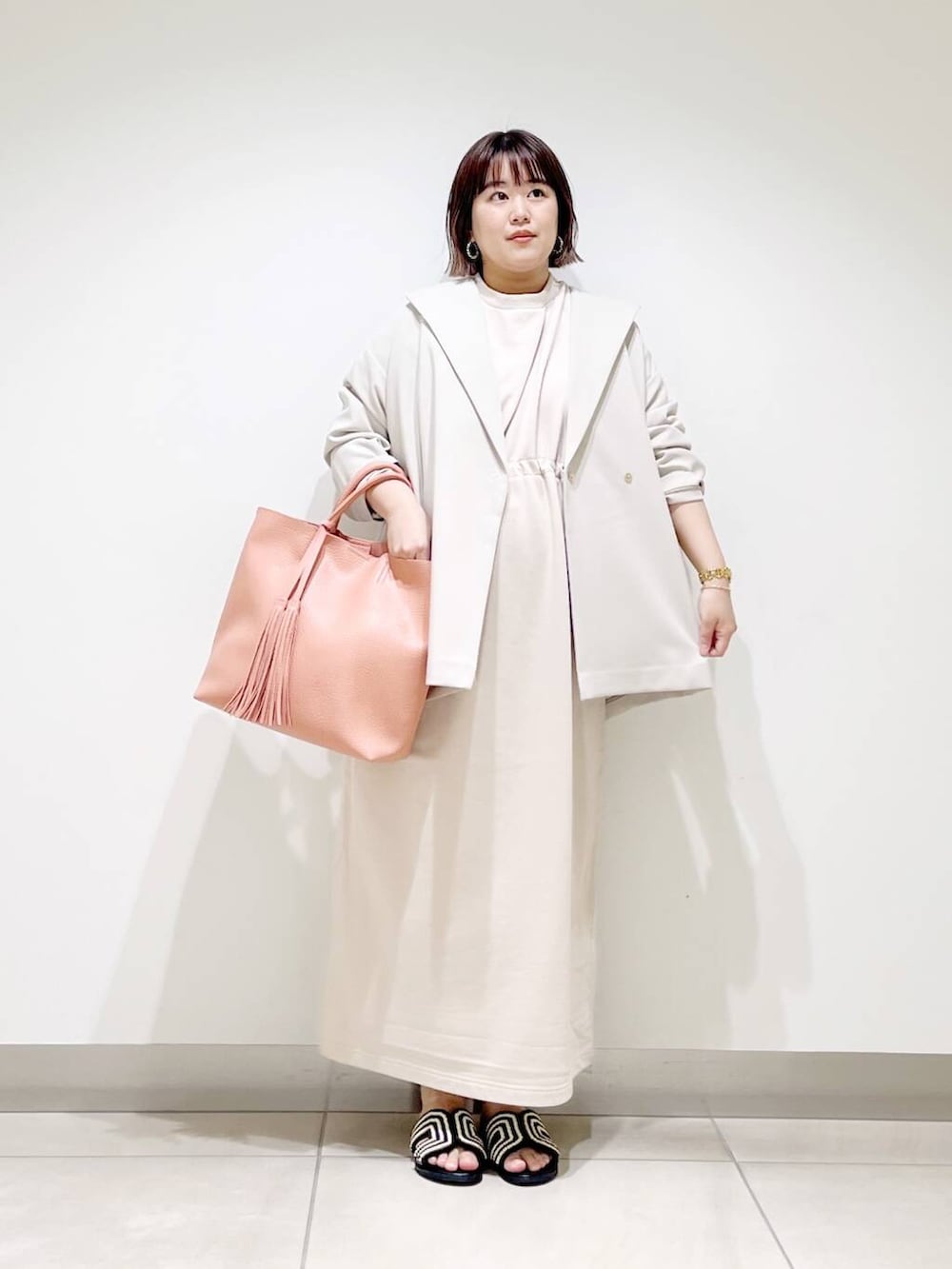 ピンク系のトートバッグ、ベージュ系のその他アウター、ベージュ系のワンピースを着用したレディースの春コーディネートの10枚目の写真