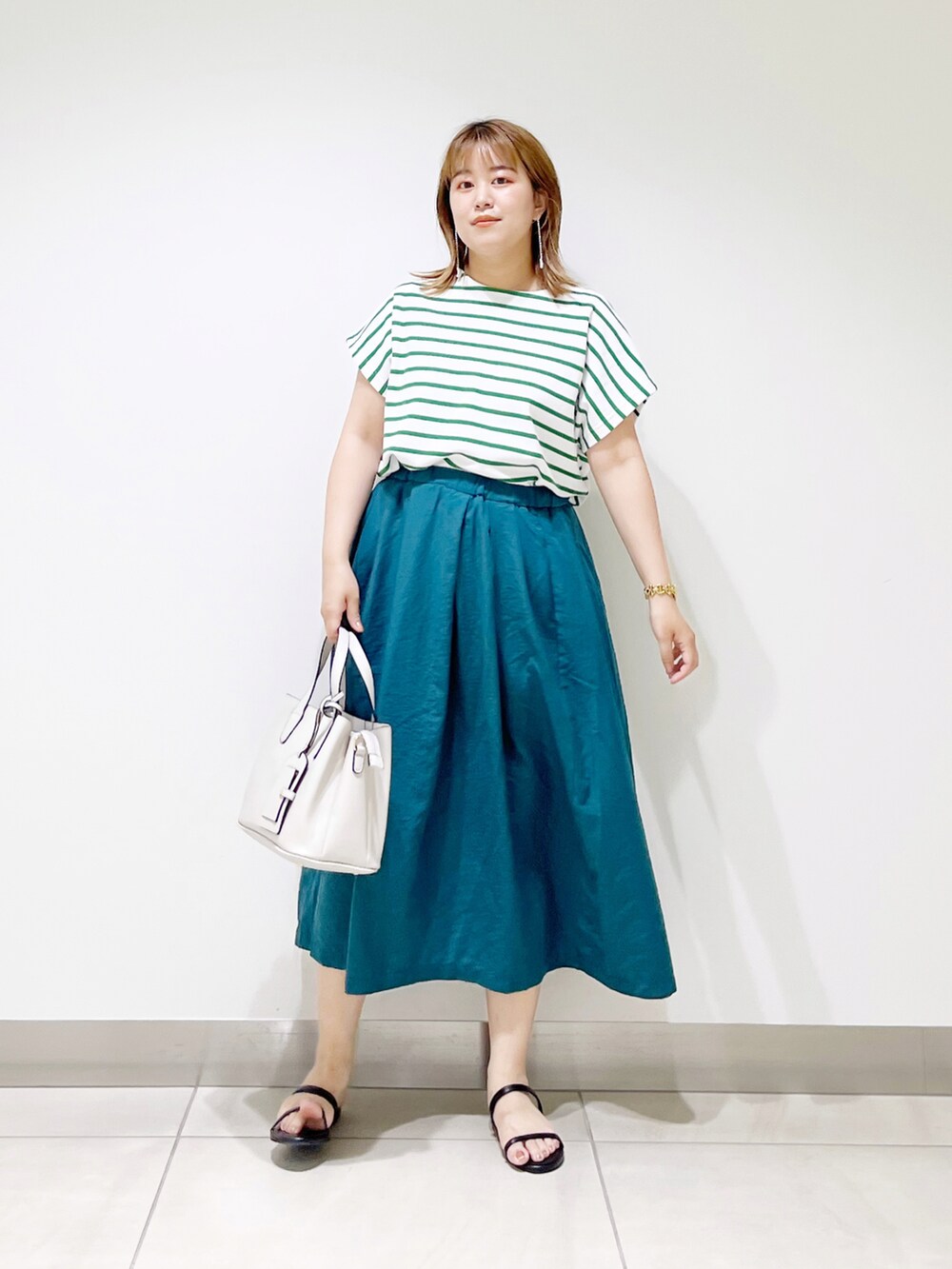 グリーン系のTシャツ/カットソー、グリーン系のスカート、グレー系のトートバッグを着用したレディースの夏コーディネートの4枚目の写真