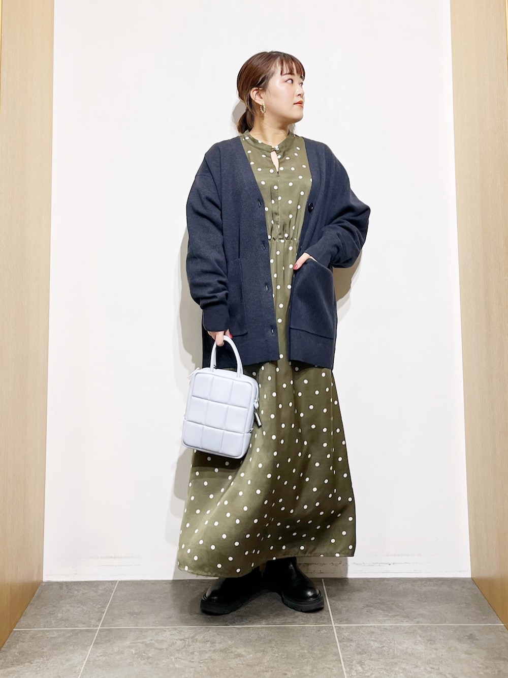 ブルー系のカーディガン/ボレロ、グリーン系のワンピース、ブルー系のハンドバッグを着用したレディースの冬コーディネートの4枚目の写真