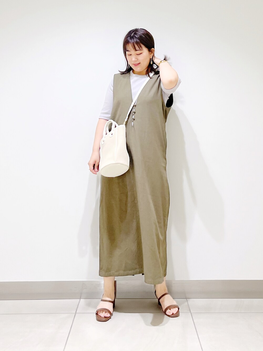 グレー系のワンピース、ベージュ系のショルダーバッグ、ブラック系のサンダルを着用したレディースの夏コーディネートの4枚目の写真