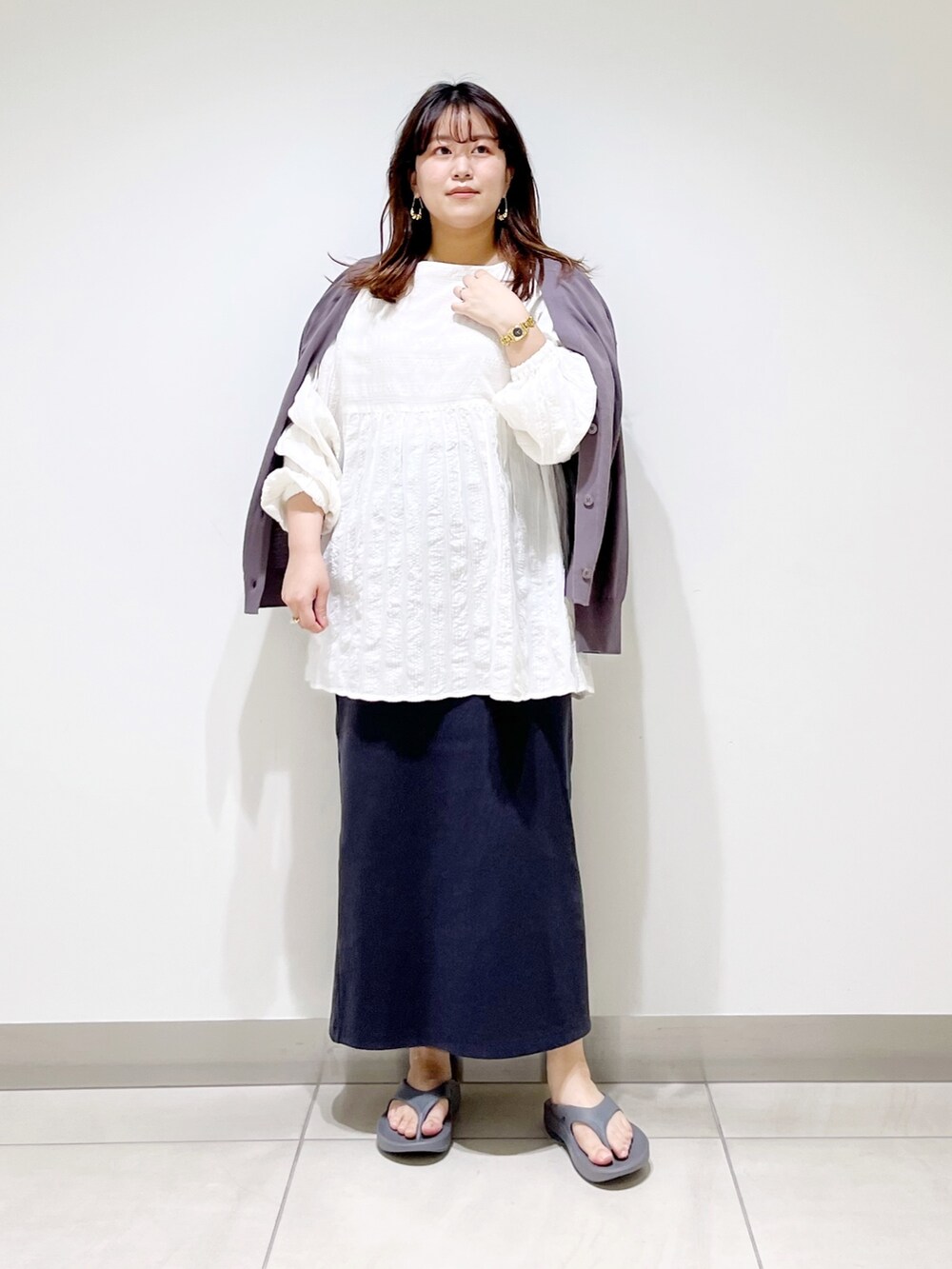 ホワイト系のシャツ/ブラウス、グレー系のカーディガン/ボレロ、グレー系のスカートを着用したレディースの春コーディネートの3枚目の写真