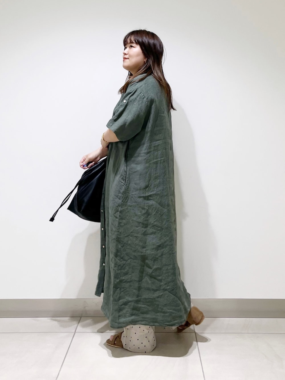 グリーン系のワンピース、ブラック系のトートバッグ、ベージュ系のその他パンツを着用したレディースの夏コーディネートの3枚目の写真