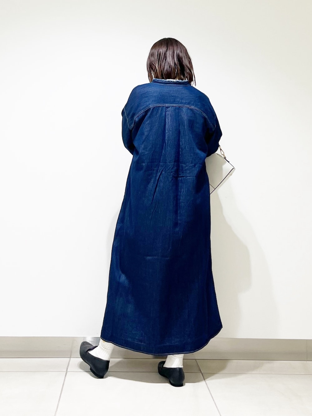 ブルー系のワンピース、ベージュ系のニット/セーター、ホワイト系のショルダーバッグを着用したレディースの秋コーディネートの5枚目の写真