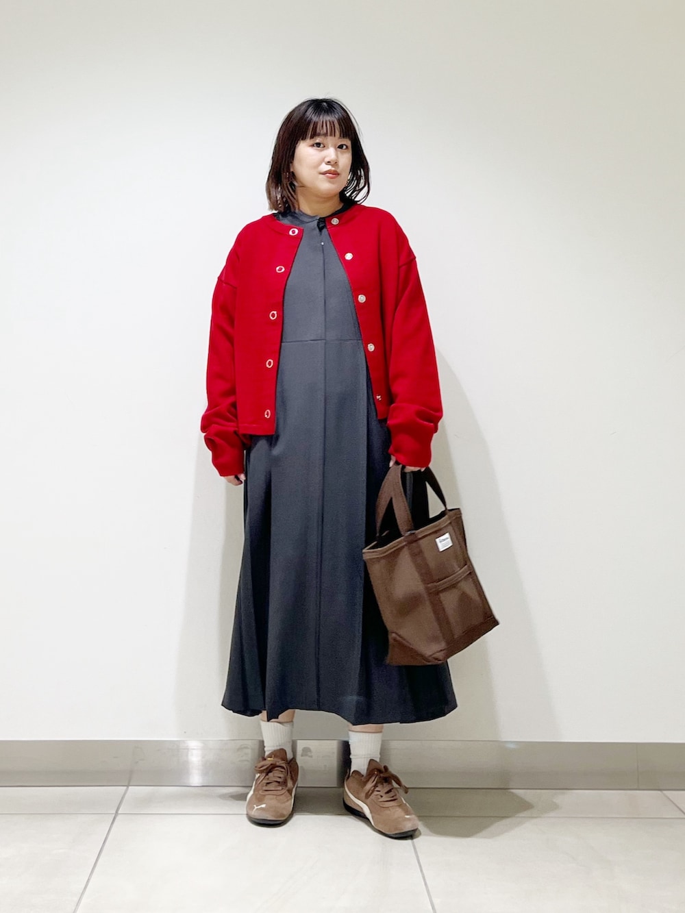 グレー系のワンピース、ブラウン系のトートバッグ、レッド系のカーディガン/ボレロを着用したレディースの秋コーディネートの10枚目の写真