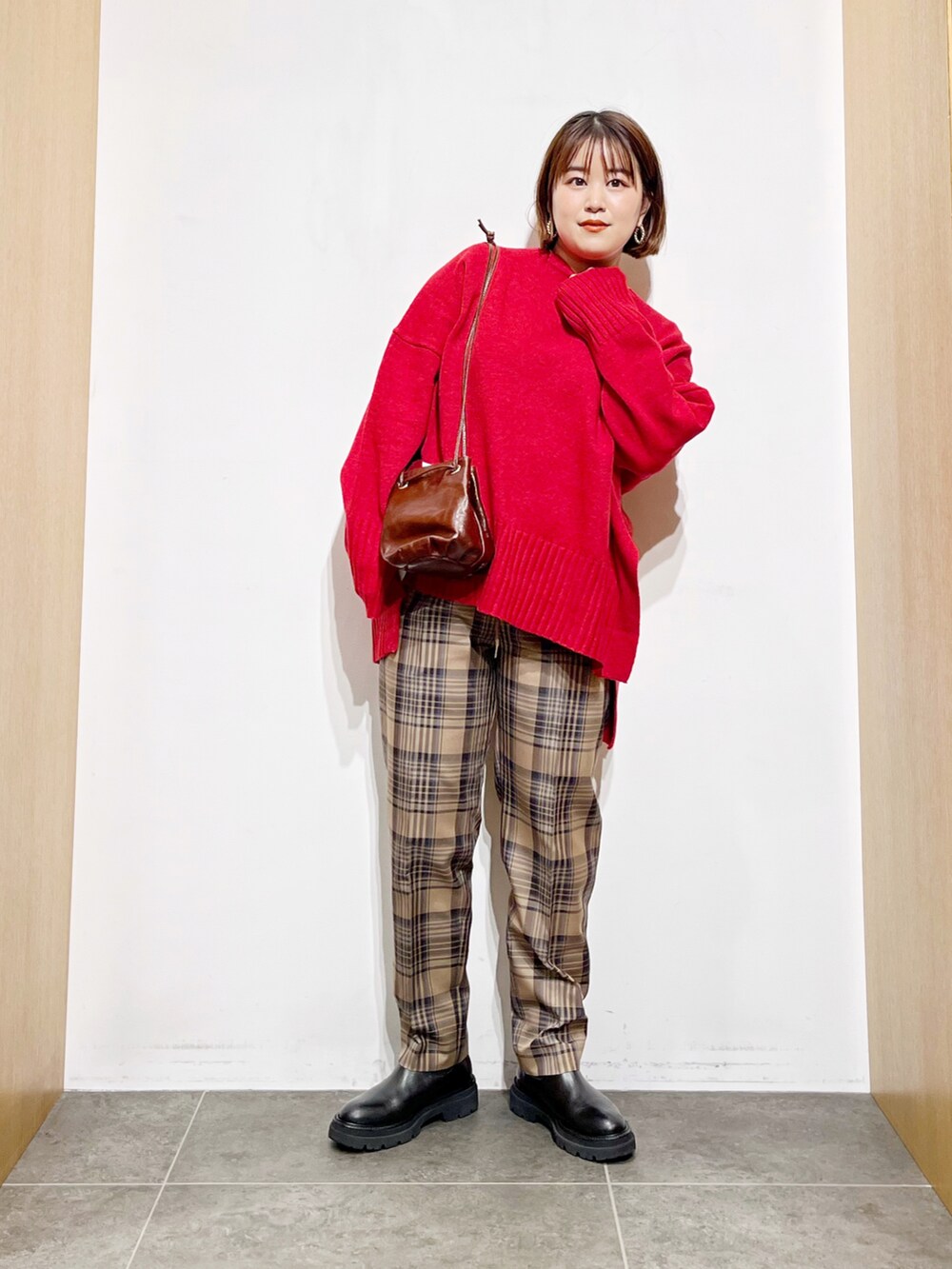 レッド系のニット/セーター、その他のその他パンツ、ブラック系のブーツを着用したレディースの冬コーディネートの5枚目の写真