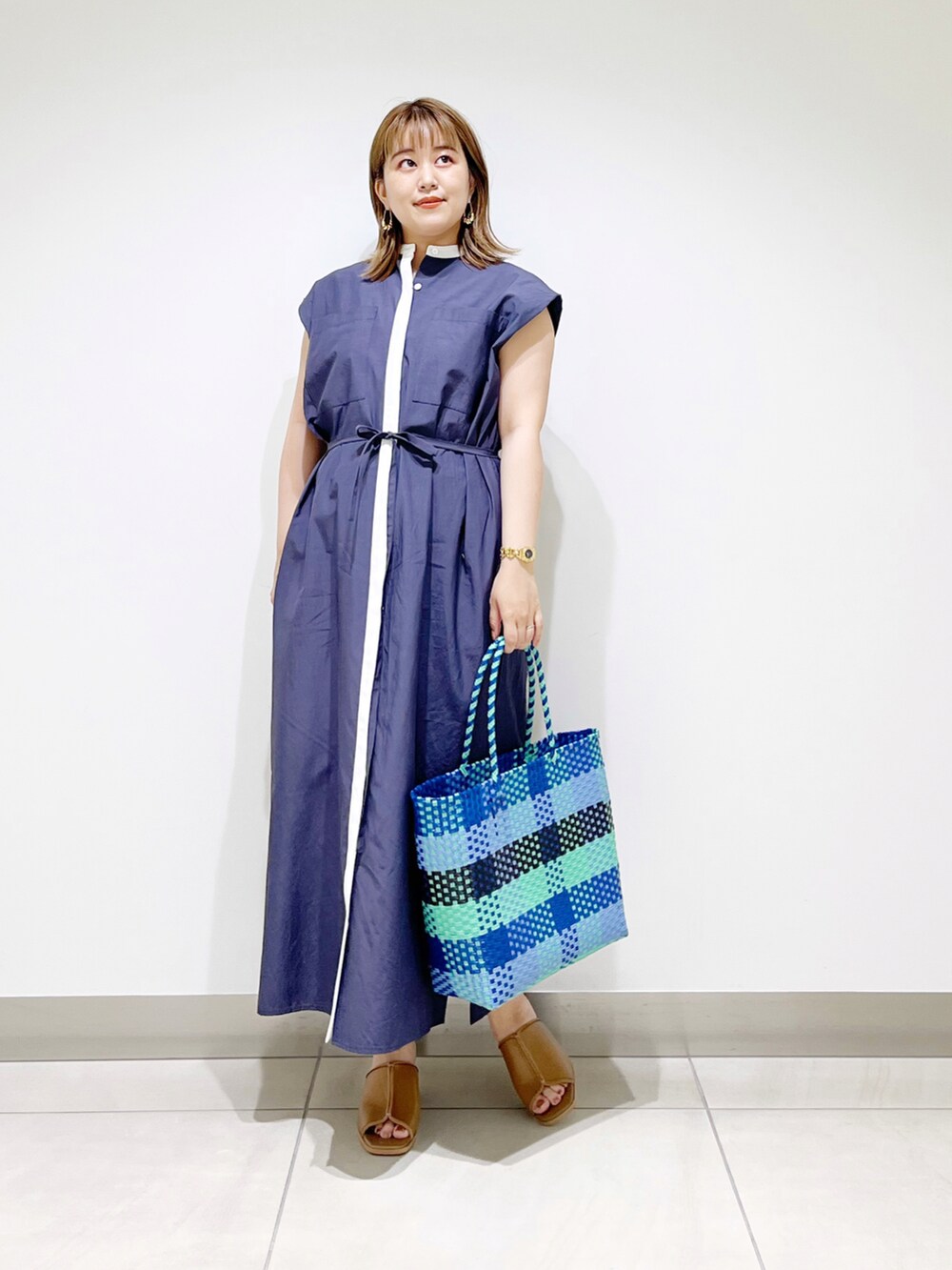ブルー系のワンピース、ブルー系のトートバッグ、ベージュ系のサンダルを着用したレディースの夏コーディネートの2枚目の写真
