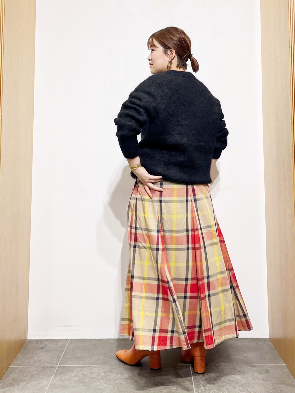 ブラック系のニット/セーター、ベージュ系のスカート、ピンク系のブーツを着用したレディースの秋コーディネートの5枚目の写真