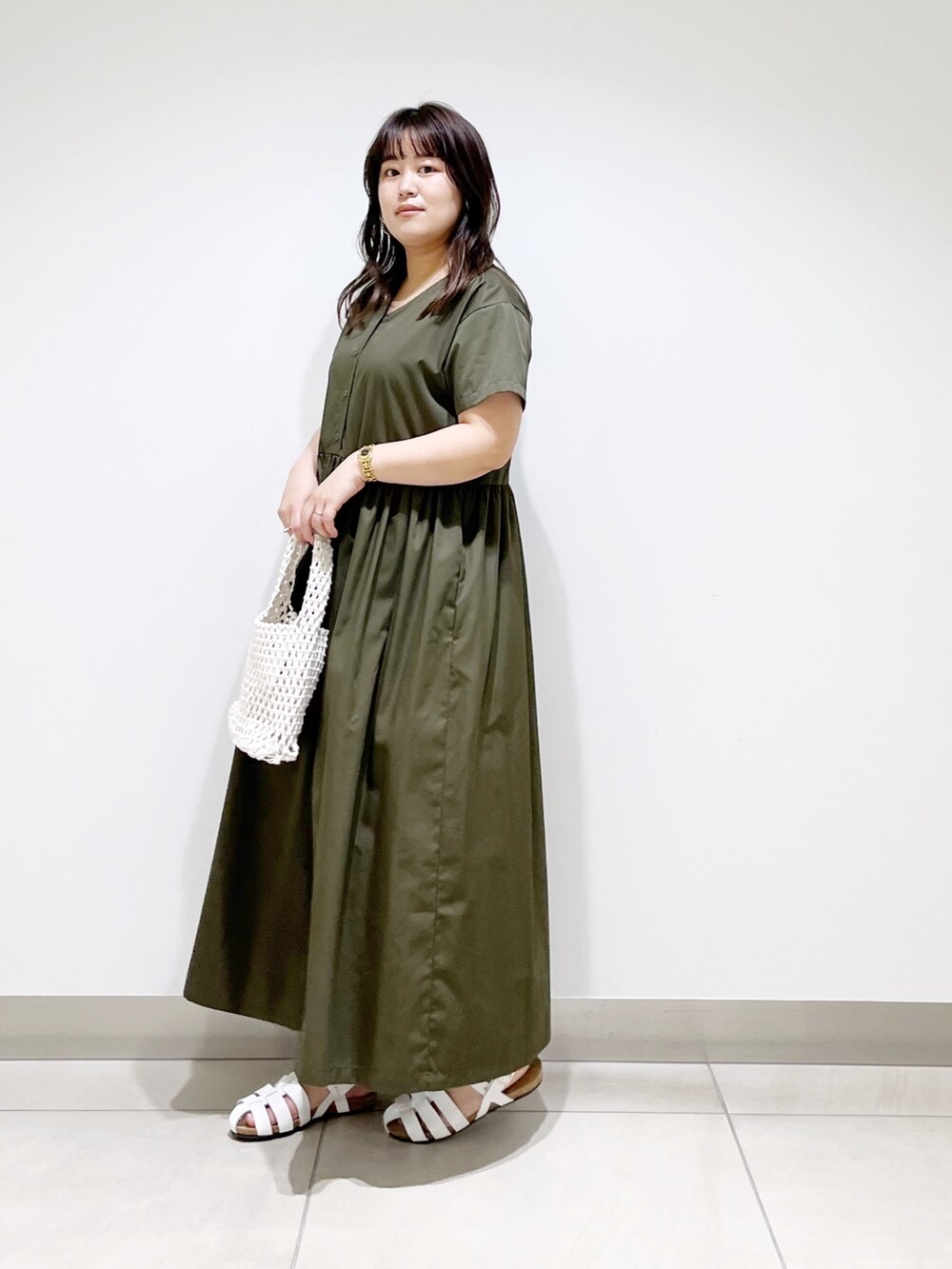 グリーン系のワンピース、ホワイト系のバッグ、ホワイト系のシューズを着用したレディースの春コーディネートの8枚目の写真