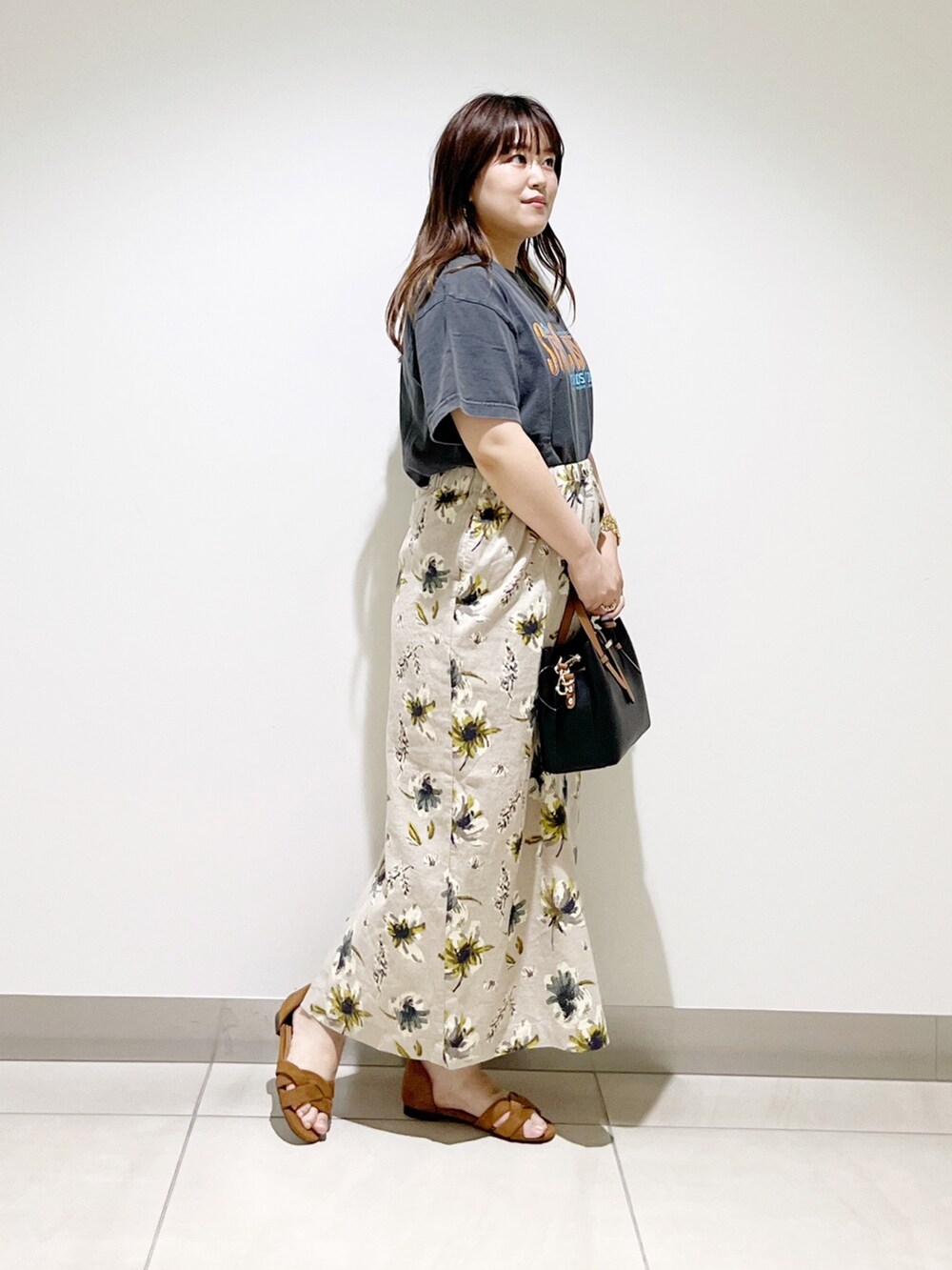 オレンジ系のTシャツ/カットソー、ブラック系のハンドバッグ、イエロー系のスカートを着用したレディースの夏コーディネートの8枚目の写真