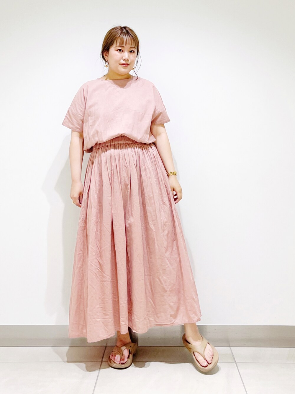 ピンク系のワンピース、ベージュ系のサンダルを着用したレディースの夏コーディネートの5枚目の写真